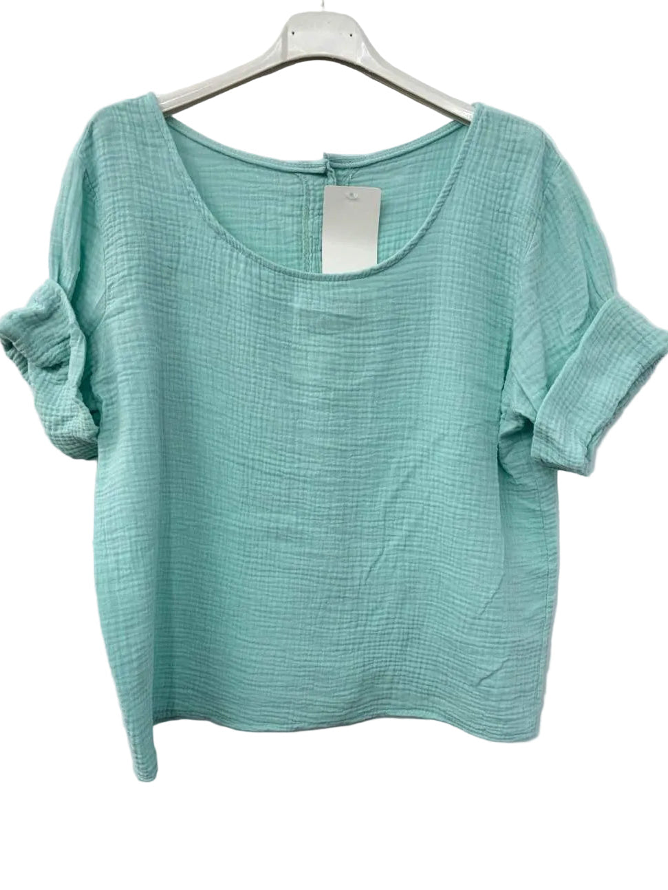 Turquoise textured top on a hanger against a white background