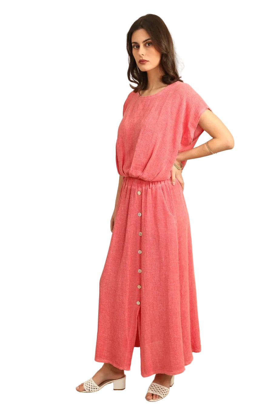 Woman wearing a coral outfit with buttons on a white background