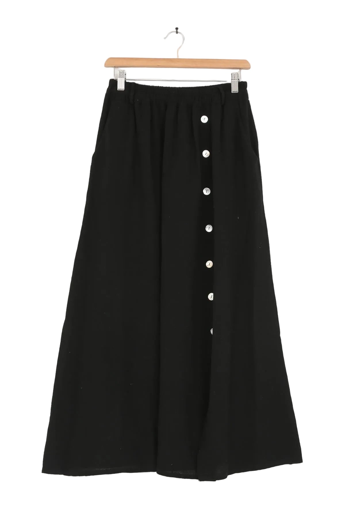 Black skirt with white buttons on a hanger against a white background