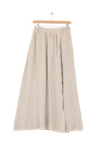 Beige skirt on a hanger against a white background