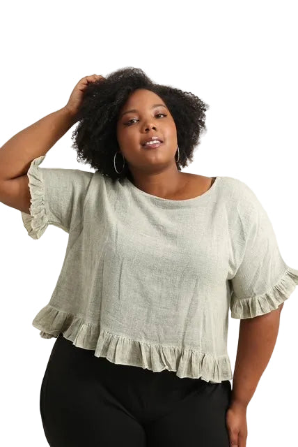 Woman wearing a light green blouse with ruffled sleeves on a white background