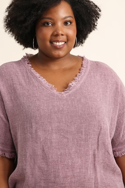 Woman wearing a bordeaux shirt with a plain background