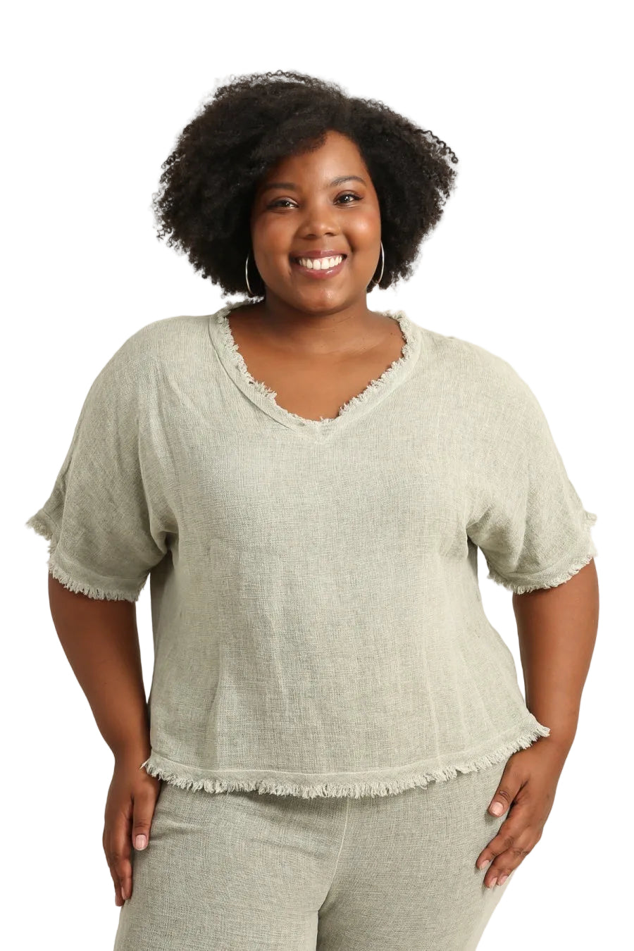 Woman wearing a duck green top and pants on a white background