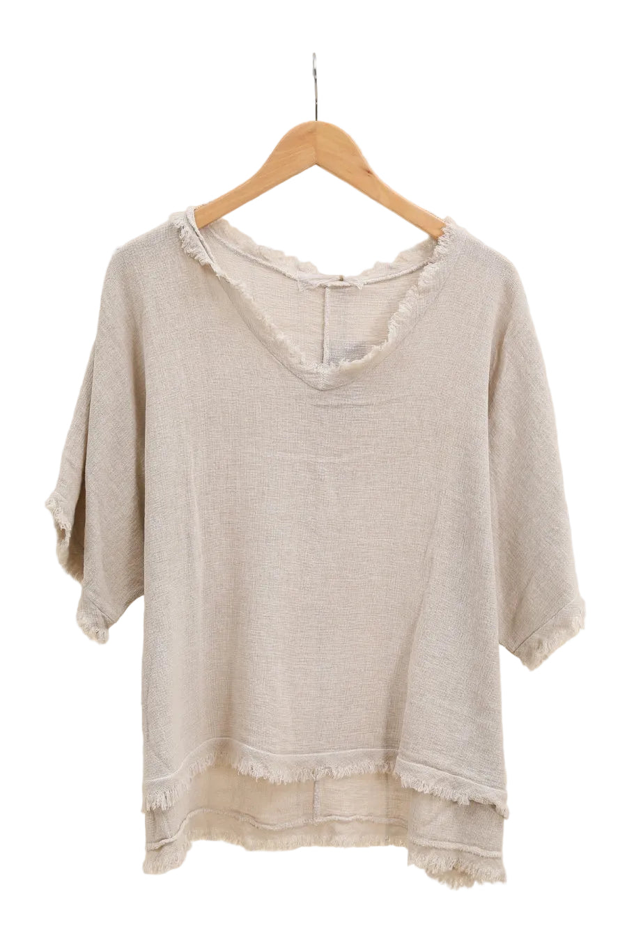 Beige top on a wooden hanger against a white background
