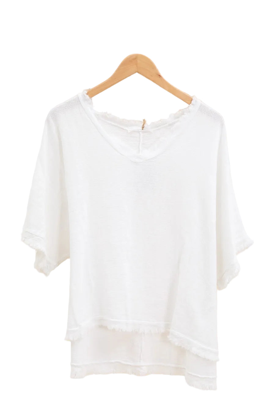 White top on a wooden hanger against a white wall.