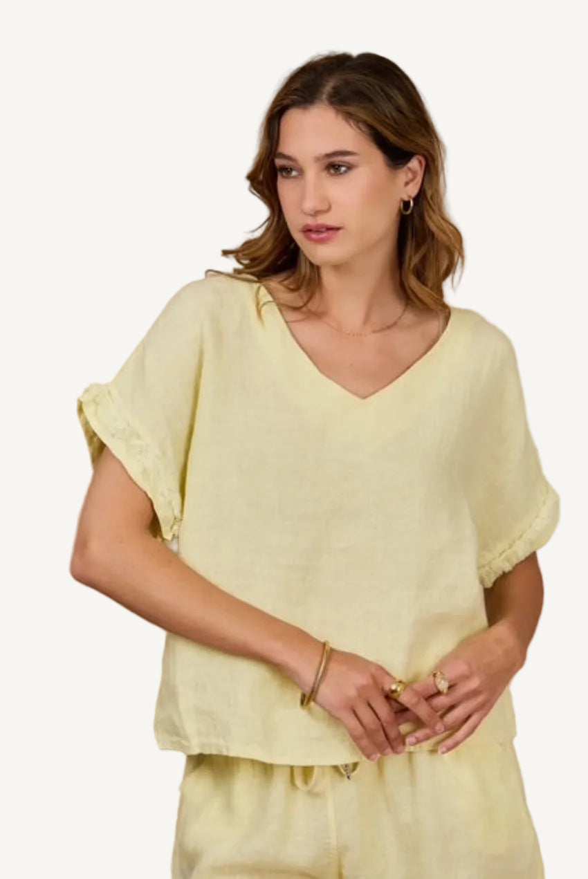 Woman wearing a light yellow top against a beige background