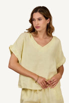Woman wearing a light yellow top against a beige background