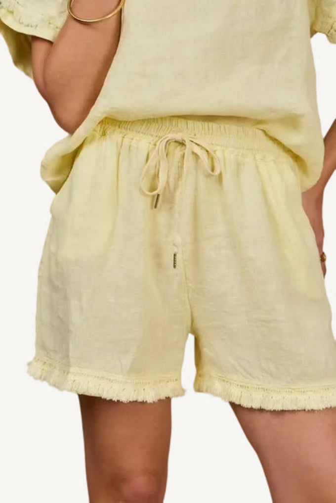 Light yellow linen shorts with fringe detail