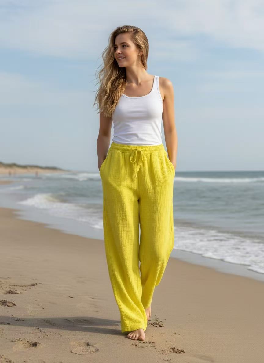Yellow cotton trousers, white t shirt with beach background.