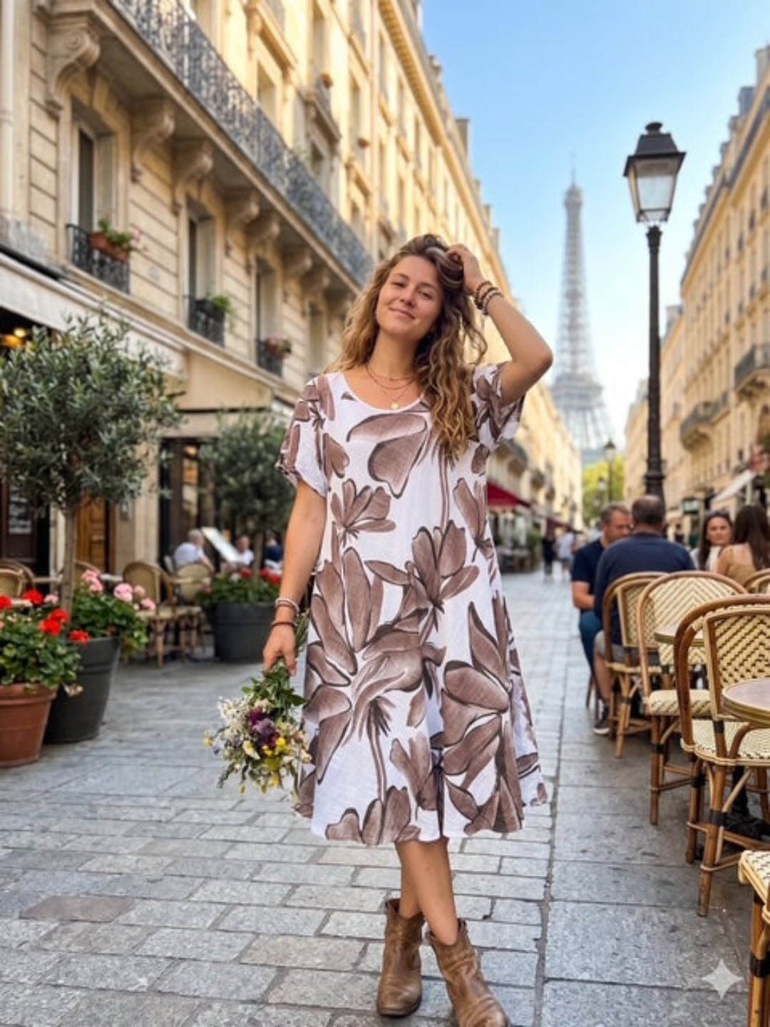 Woman in a floral dress standing on a Paris street with the Eiffel Tower in the background.