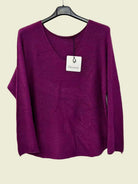 A long-sleeve knit sweater in a rich magenta-purple color, 