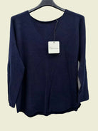 A dark navy blue long-sleeve knit top hanging on a black hanger 