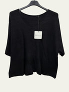 A black women's knit top with a wide scoop neckline and elbow-length sleeves, hanging on a black hanger 