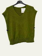 An olive green sleeveless V-neck knit sweater vest hanging on a black hanger against a white wall, featuring small dark buttons on the sides.
