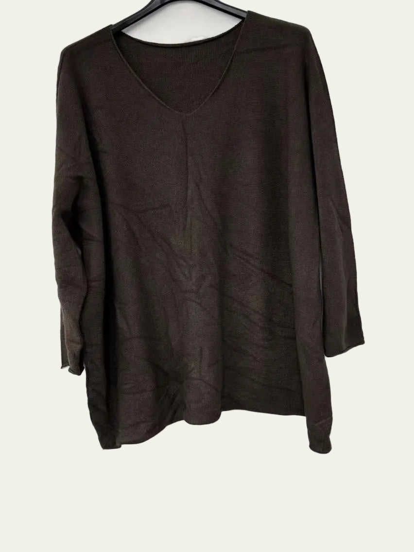 A dark brown long-sleeve knit top with a V-neck, hanging on a black hanger against a plain white wall.