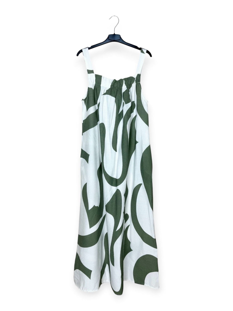 White dress with khaki abstract pattern on a hanger against a white background