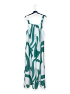 Turquoise and white patterned dress on a hanger against a white background