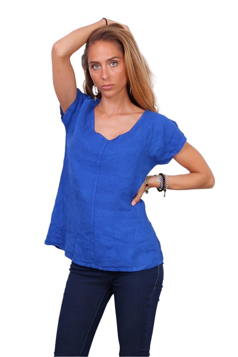 Royal blue linen top worn with dark blue jeans against a white background