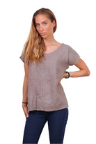 Taupe linen top worn with denim jeans on a white background