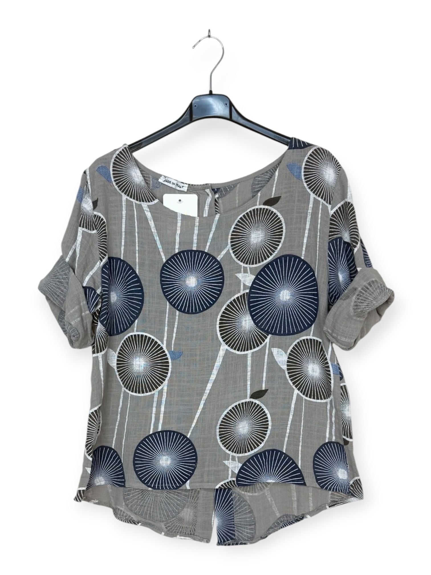 taupe top with blue floral pattern on a hanger against a white background