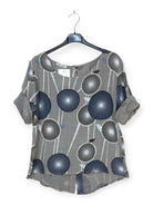 taupe top with blue floral pattern on a hanger against a white background