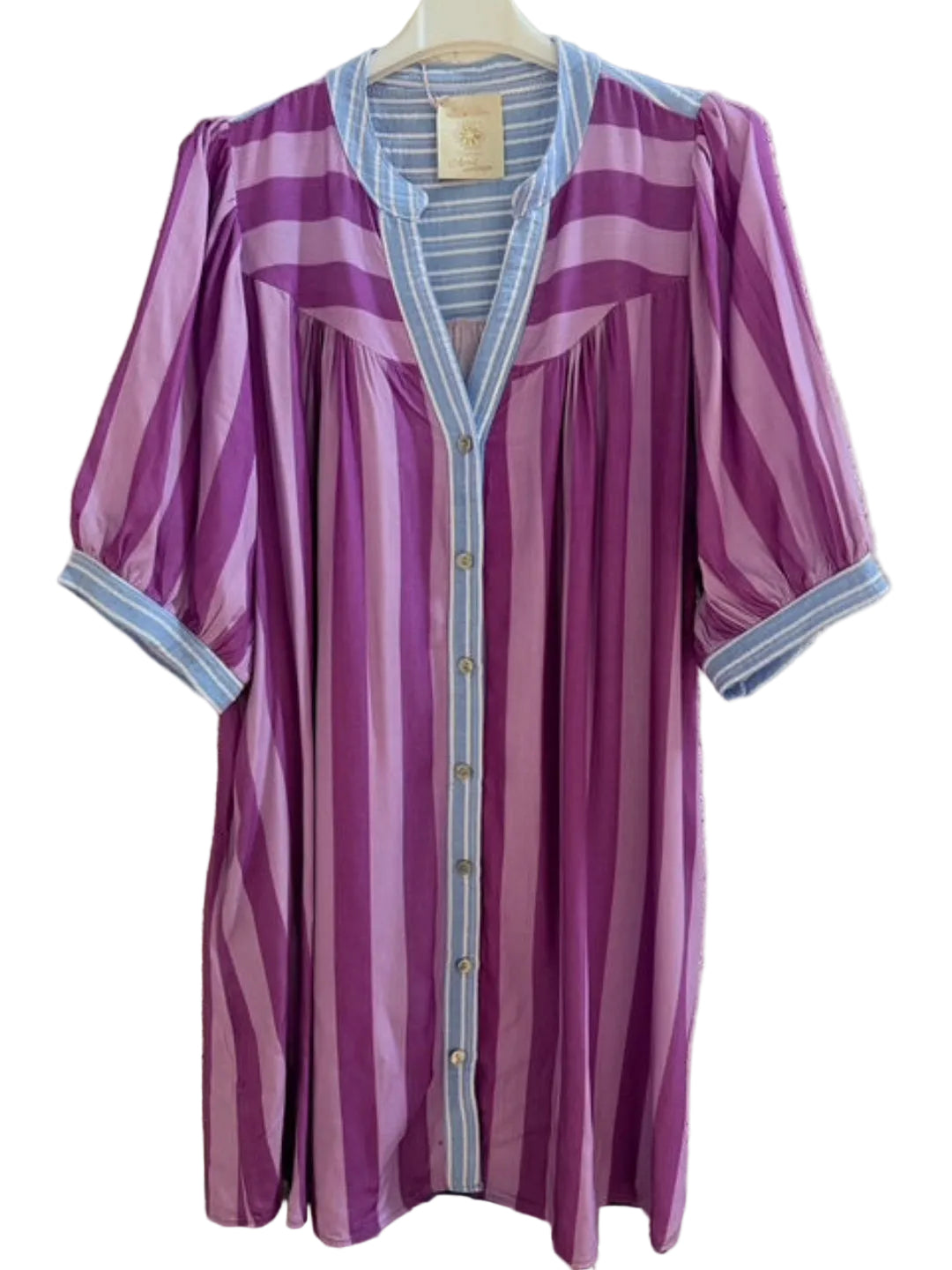 Purple striped dress with blue trim on a hanger against a textured wall.