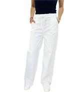 White pants worn by a person on a white background