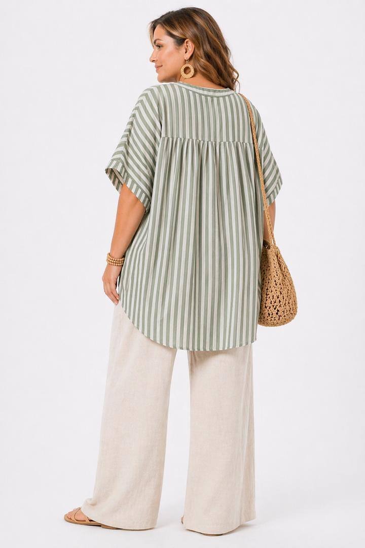 Woman wearing a green and white striped shirt with wide-leg pants on a white background