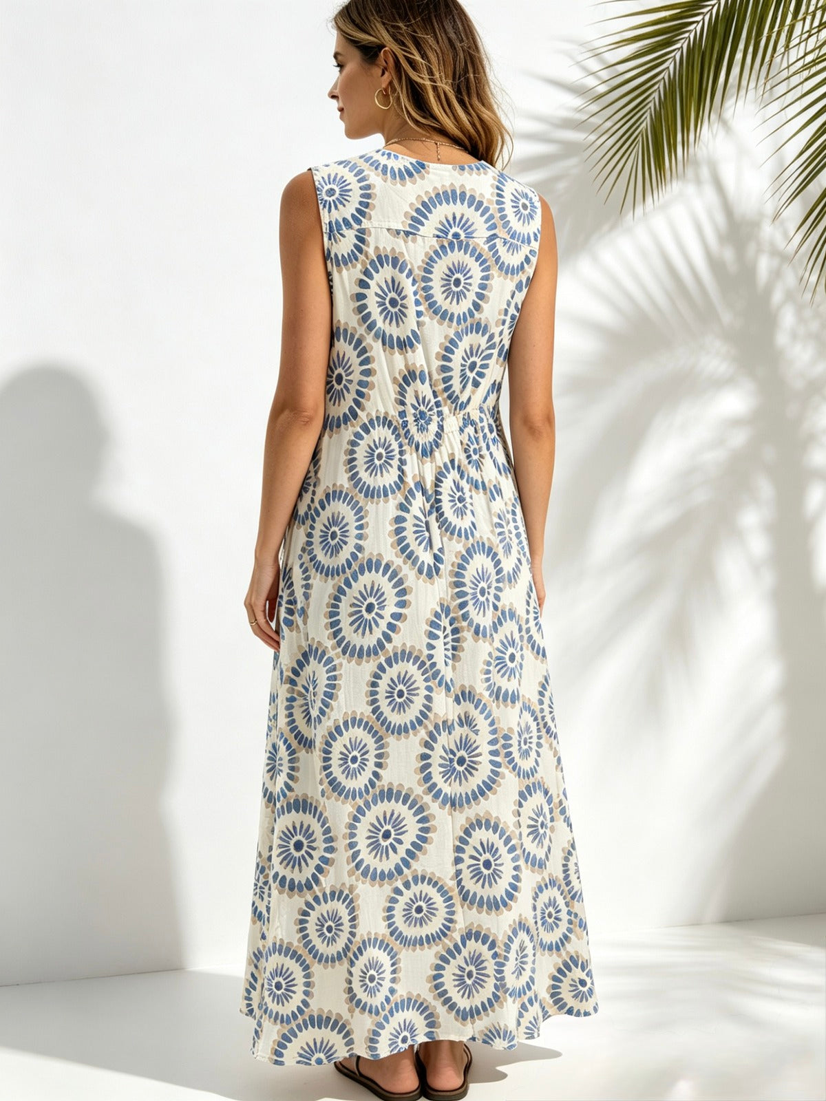 back view of lady wearing sky blue printed sleeveless dress