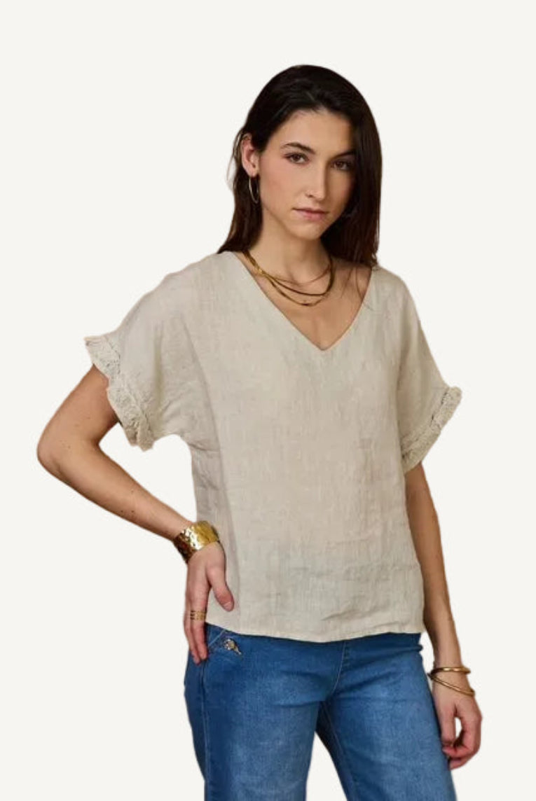 Woman wearing a beige linen v neck  and blue jeans