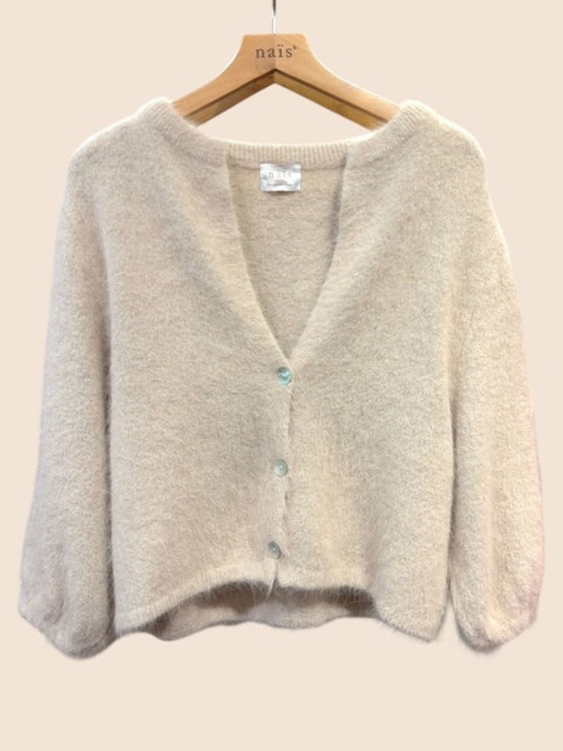 A soft knit cardigan sweater in beige, hanging on a wooden hanger - the cardigan features a V-neck, long sleeves, and a front button closure with light blue buttons.