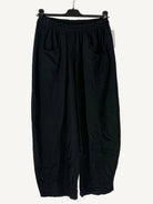 Black wide-leg pants on a hanger against a light background