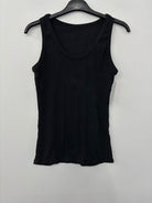 Black tank top on a hanger against a white background