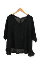 Black top on a hanger against a white background