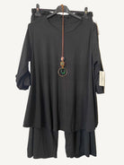 Black trouser and top set plus size a hanger with a textured gray background