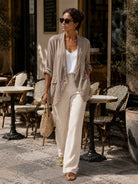 Woman in a casual outfit walking outdoors near a cafe.