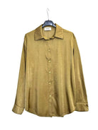 A long-sleeve button-up shirt in a olive green colour, hanging on a black hanger against a plain white background.