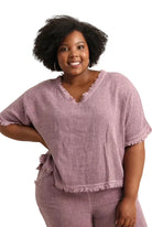 Woman wearing a bordeaux outfit with a plain background