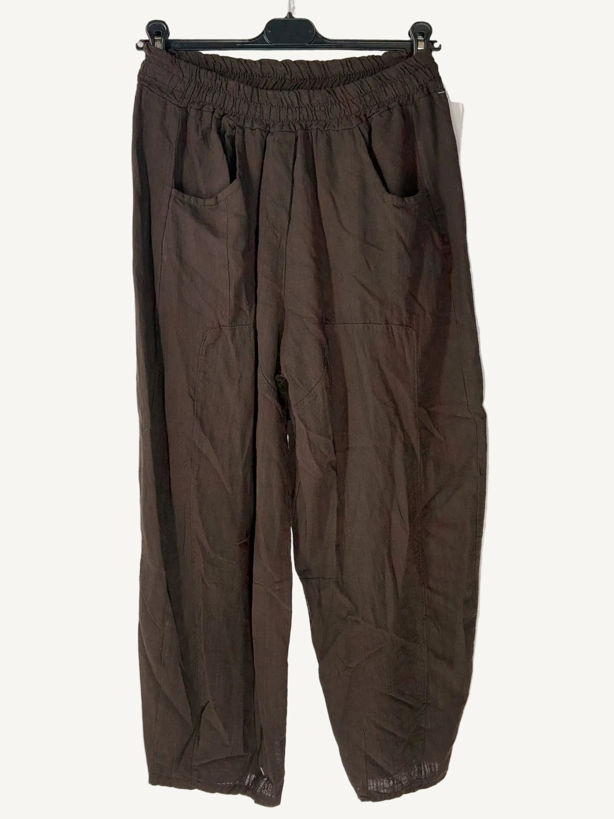 Brown pants on a hanger against a light background