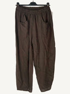 Brown pants on a hanger against a light background