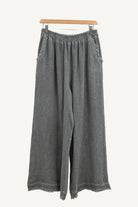 Charcoal grey wide-leg pants on a hanger against a white background