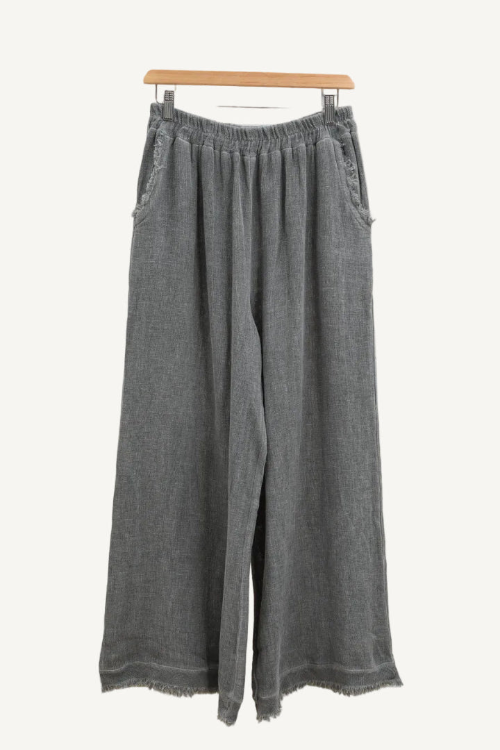 Charcoal grey wide-leg pants on a hanger against a white background
