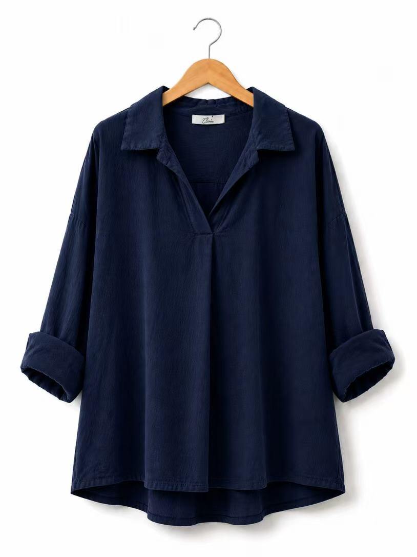 A dark navy blue long-sleeve collared shirt with rolled cuffs, hanging on a wooden hanger against a plain white background.