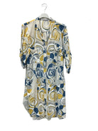 A lightweight button-front shirt dress with three-quarter sleeves, featuring an abstract swirl pattern in navy blue, mustard yellow, and white on a sheer fabric, hanging on a white hanger against a white wall.
