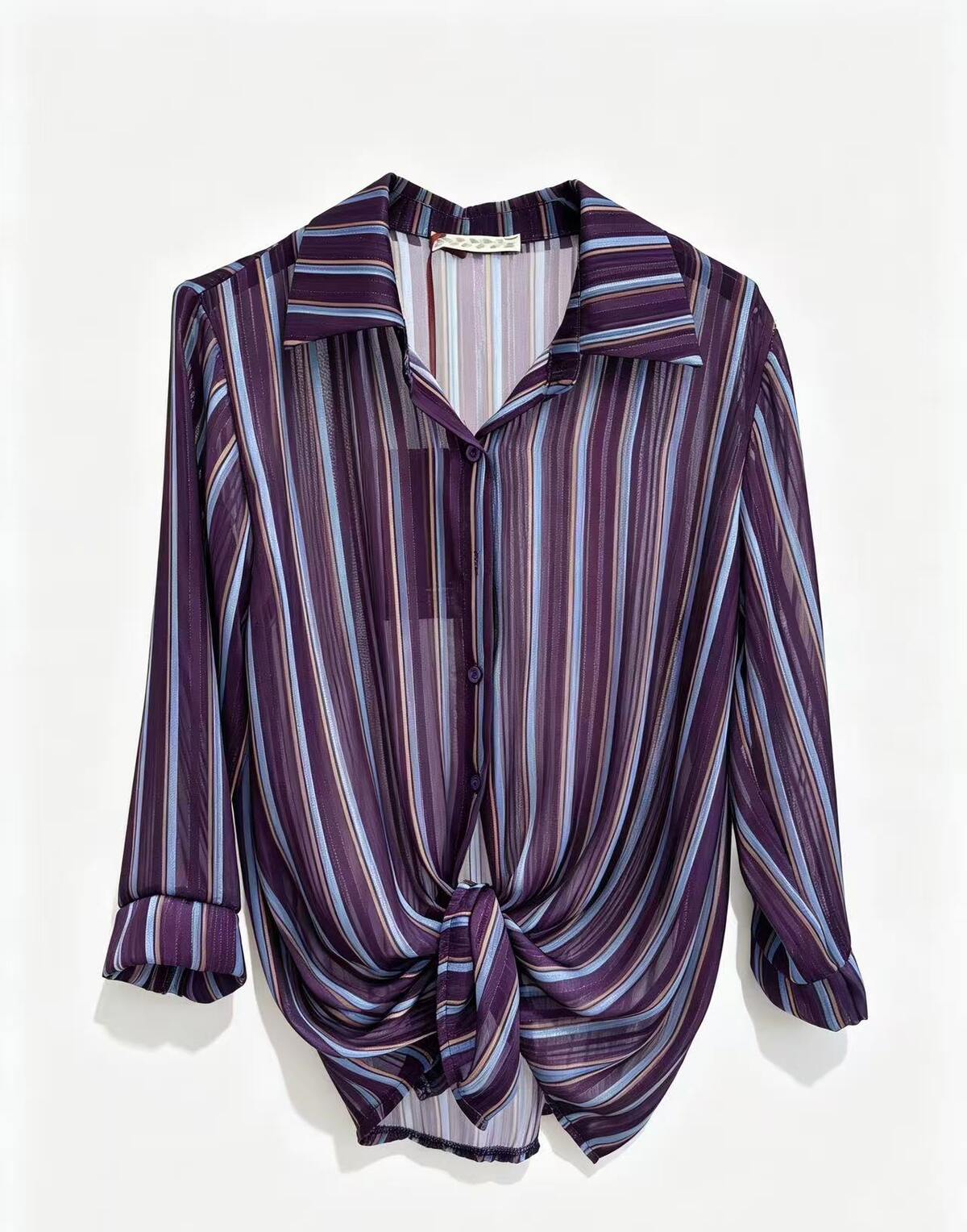 A long-sleeve button-up shirt with a purple, styled with a front knot detail, shown against a plain white background.