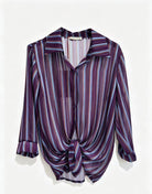 A long-sleeve button-up shirt with a purple, styled with a front knot detail, shown against a plain white background.
