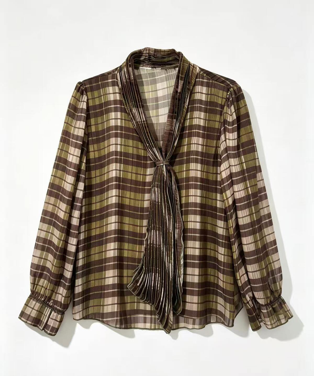A long-sleeve plaid blouse with a shawl collar and front tie, shown hanging against a plain white background.