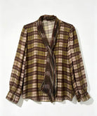 A long-sleeve plaid blouse with a shawl collar and front tie, shown hanging against a plain white background.
