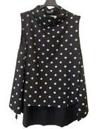 A sleeveless black cowl-neck top with white polka dots