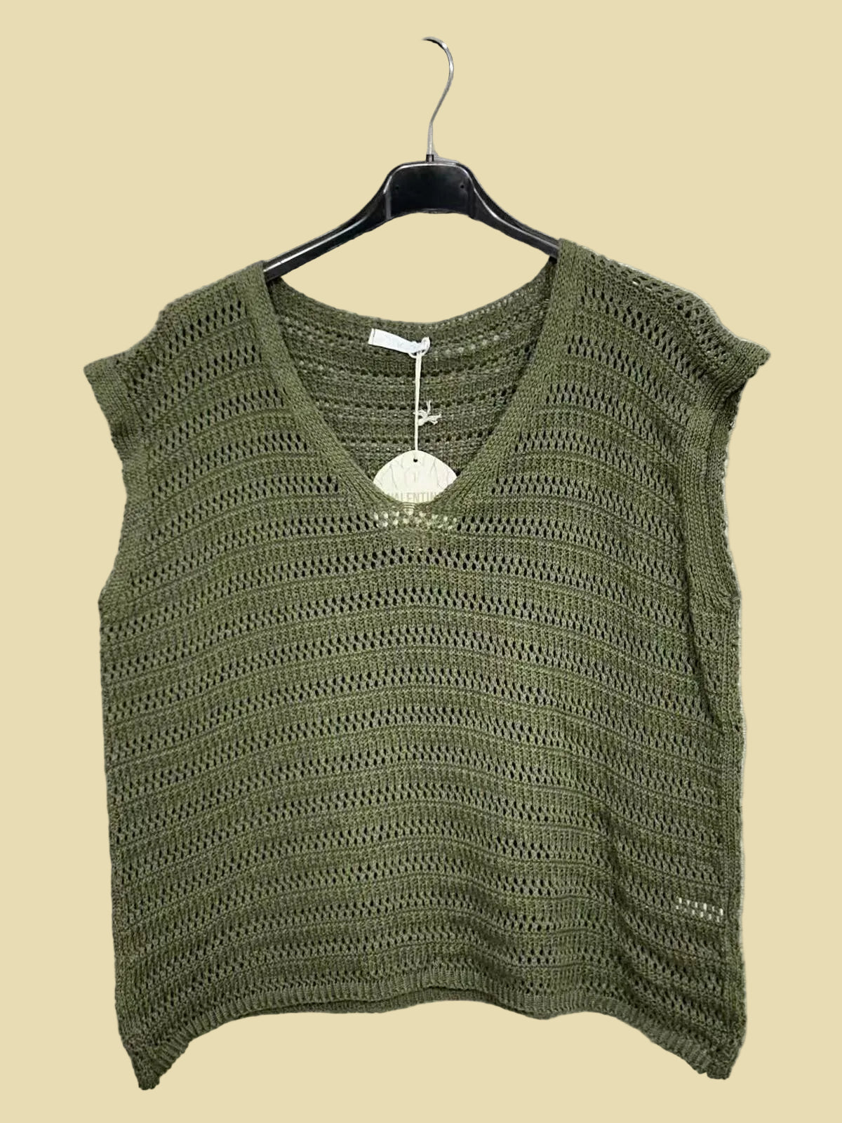 Green knitted top on a hanger